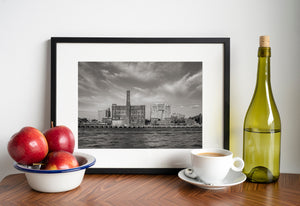Black and white view of the Domino Sugar Plant with cranes along the shoreline.