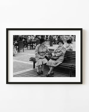 Two women on a bench in Bucharest, photographed in black and white.