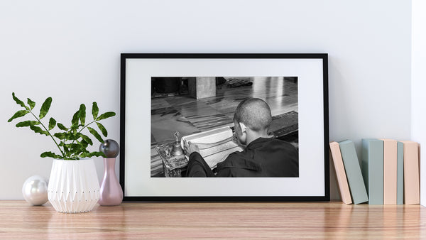 Focused young monk in a monastery – black and white wall art