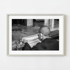 Young Buddhist monk studying sacred texts – black and white