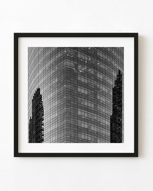 Black and white photograph of reflections on a glass office building in Buenos Aires.