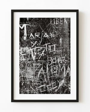 Black and white photograph of layered graffiti on a Buenos Aires wall.
