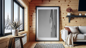 A narrow modern facade contrasts with empty sky in a vertical black and white photograph.