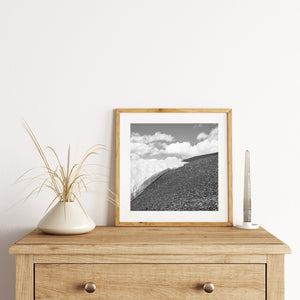 Canadian alpine landscape with snow, dark rocks and bright clouds in monochrome.