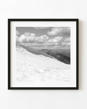 Black and white photograph of a snowy slope and distant ridges in the Bugaboo Mountains.