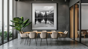 Square mountain landscape with a forested shoreline and mirrored alpine ridges.