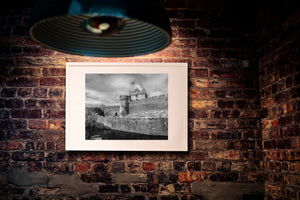 Weathered masonry and crenellated walls form a detailed black and white castle scene.