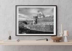 Irish architectural photograph of Cahir Castle with dark water below its stone walls.