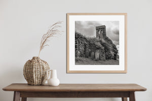 Square black and white architectural photograph of church ruins and a quiet graveyard.