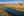 Blue water contrasts with sunlit golden fields in a California river landscape.