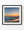Orange afterglow lights the California coast above soft ocean waves and reflective wet sand.