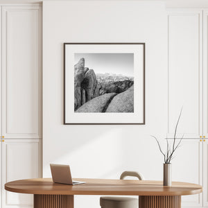 Square California landscape with textured stone and snowy mountains on the horizon.