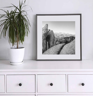 California mountain scene with rounded rocks, deep crevices and bright snowy summits.