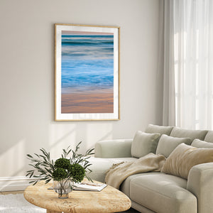 Blue waves and warm sand reflections create a quiet California sunset scene.