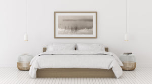 Warm grey tones soften a calm lake and its misty reflected shoreline.