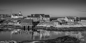 Historic fishing village buildings reflected in calm water