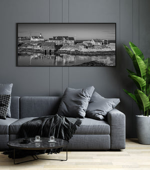 Lighthouse and village reflected in still harbor