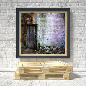 Decay and rubble beneath old brick factory wall