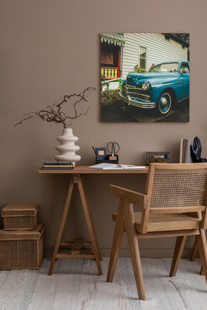 vintage automobile parked near historic house with decorative wooden porch