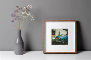 blue retro car parked in small town Ontario with flowers and siding house