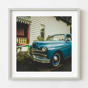 blue vintage Plymouth car parked beside colorful porch Niagara on the Lake