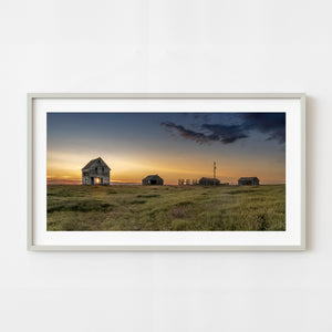 Abandoned Saskatchewan farmhouse at sunset with prairie grass