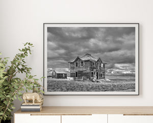 black and white abandoned homestead with broken windows prairie