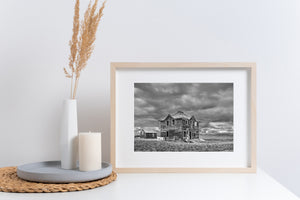 rural prairie house ruins with rolling hills and clouds