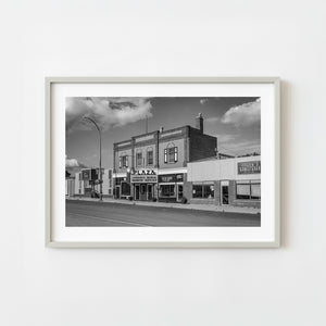 Historic brick plaza building on a rural Saskatchewan main street in black and white
