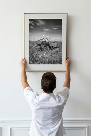 abandoned prairie tractor surrounded by wild grass monochrome image
