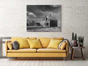 Lonely prairie farmhouse beneath dramatic cloud cover