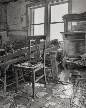 Broken wooden chair surrounded by plaster and debris