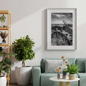 Rusty tractor steering wheel and curved metal panels in overgrown field