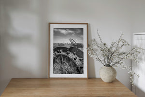 Old tractor relic in grass with wide sky and low prairie horizon