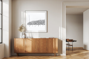Wooden sideboard in a modern living room with a framed picture on the wall.