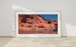 Panoramic Arizona photograph of layered sandstone cliffs and rugged canyon terrain.