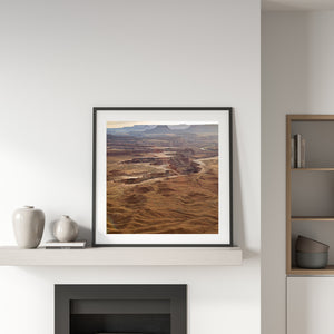 Bands of pale sandstone and darker canyon shadows cross a broad desert view.