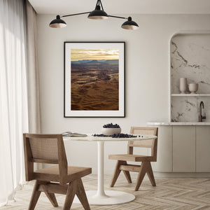 Distant flat topped mesas rise above a broad expanse of weathered Utah desert.