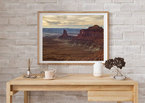 Panoramic Canyonlands landscape with glowing clouds and weathered red buttes.