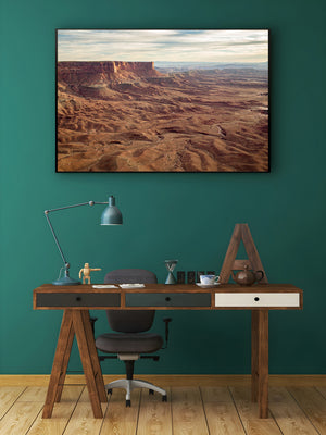 Winding ravines and weathered sandstone surround a prominent flat topped mesa.