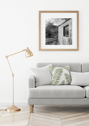 Weathered plaster and a wooden window frame fill a Northern Ireland coastal photograph.