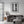Weathered white doors reveal a woman and patterned floor inside a Cartagena building.