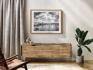 Charles Bridge spans the Vltava beneath a richly textured black and white sky.