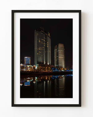 Chengdu Shangri-La hotel towers glow above dark river reflections in a night photograph.
