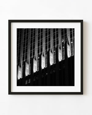 Black and white night photograph of a Chicago Art Deco facade with brightly illuminated stone columns.