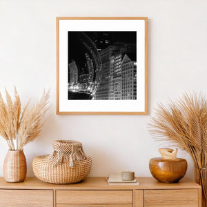 Black and white sculpture detail with curved reflections of Chicago’s illuminated skyline.