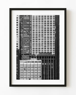 Black and white Chicago building facades form layered grids of windows around a small plume of steam.