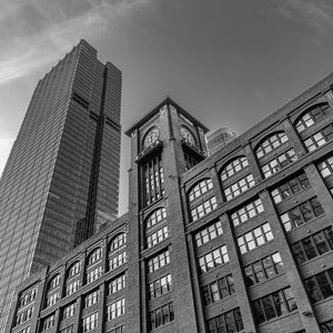 A historic Chicago brick building and clock tower contrast with a tall modern office facade.