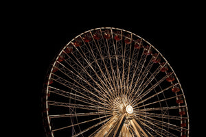 Golden spokes radiate from the bright center of a Chicago Ferris wheel at night.