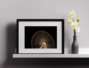A luminous wheel rim and fine lighted spokes form a curved pattern against open darkness.